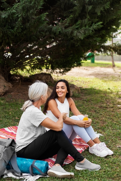 Photo gratuite amis faisant du yoga ensemble dans le parc