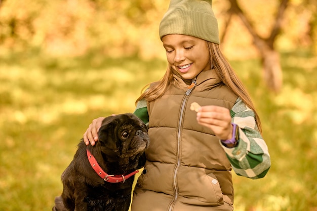 Amis. Une fille nourrit son chien et a l'air heureuse