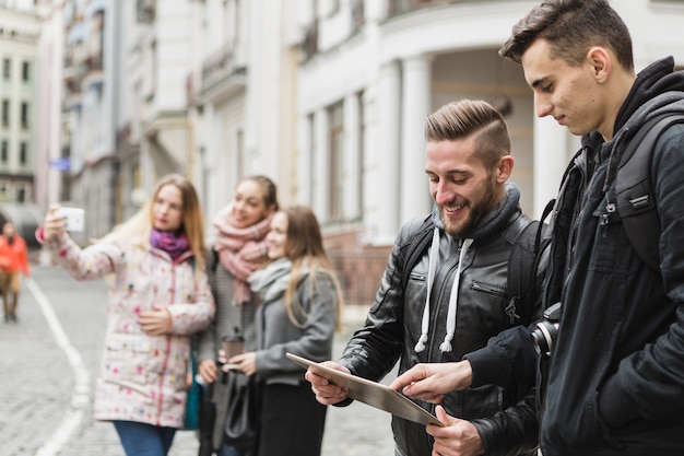 Photo gratuite amis avec des gadgets dans la rue