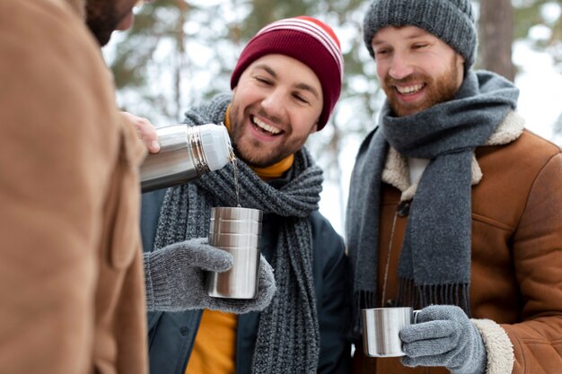 Amis heureux avec des boissons l'heure d'hiver