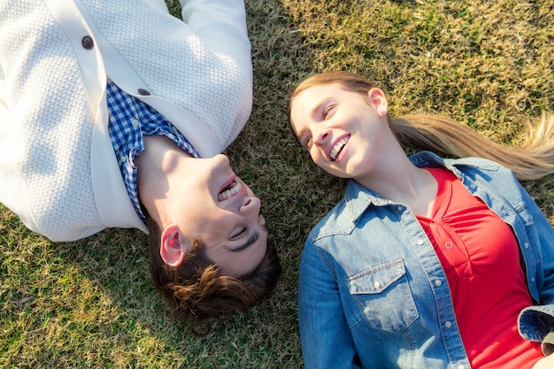 amis heureux couché sur l&#39;herbe et rire