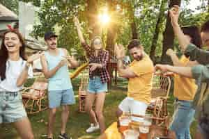 Photo gratuite des amis heureux ont une bière et un barbecue en journée ensoleillée