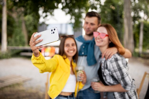 Amis heureux de plan moyen prenant des selfies