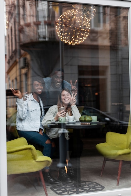 Amis heureux posant par la fenêtre