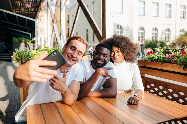 Amis interculturels au restaurant prenant selfie