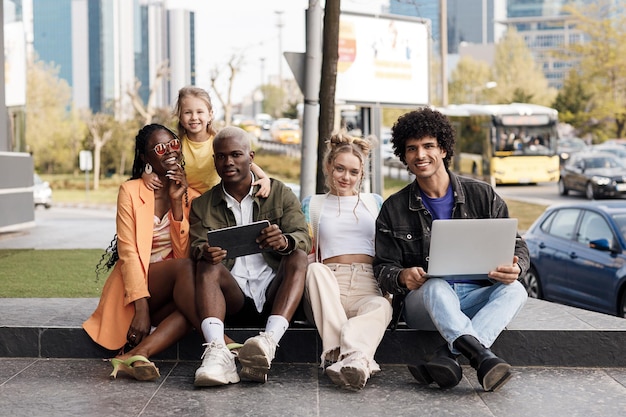 amis internationaux avec ordinateur portable et tablette à l'extérieur