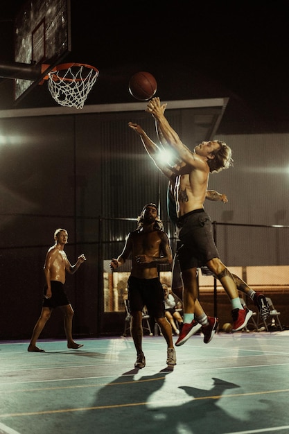 Des amis jouent au basket. Les jeunes hommes jouent au basket dans la rue.