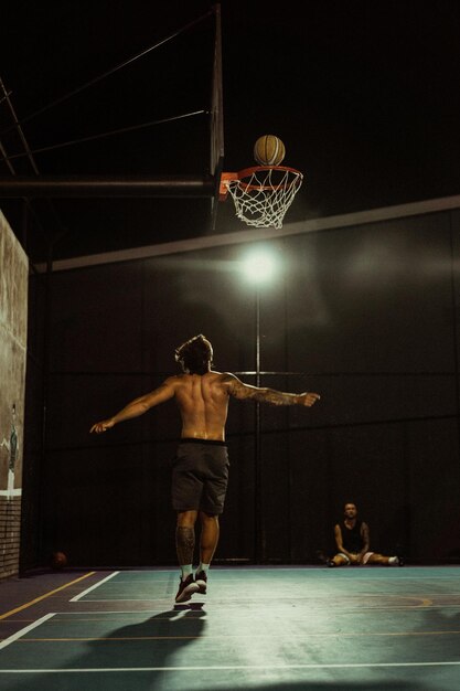 Des amis jouent au basket. Les jeunes hommes jouent au basket dans la rue.