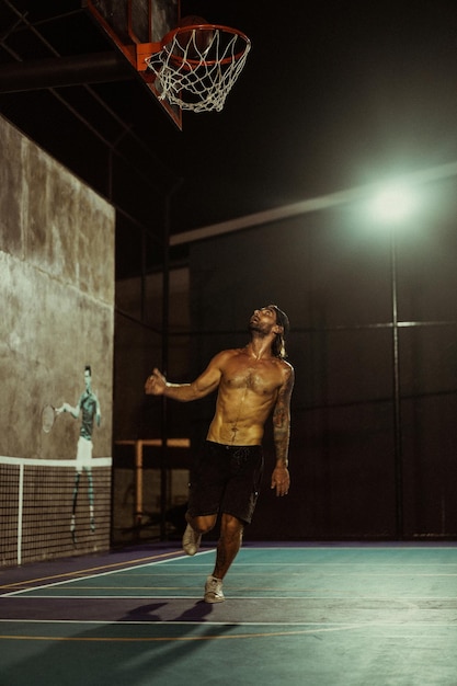 Des amis jouent au basket. Les jeunes hommes jouent au basket dans la rue.