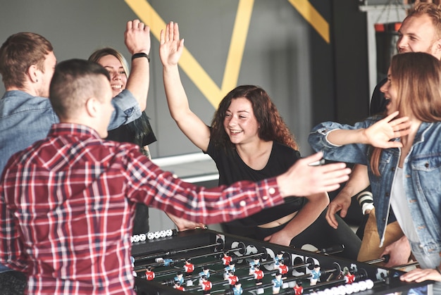 Les amis jouent ensemble à des jeux de société, au baby-foot, s'amusent pendant leur temps libre.