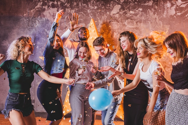 Amis jouissant d&#39;une fête avec des confettis et des ballons