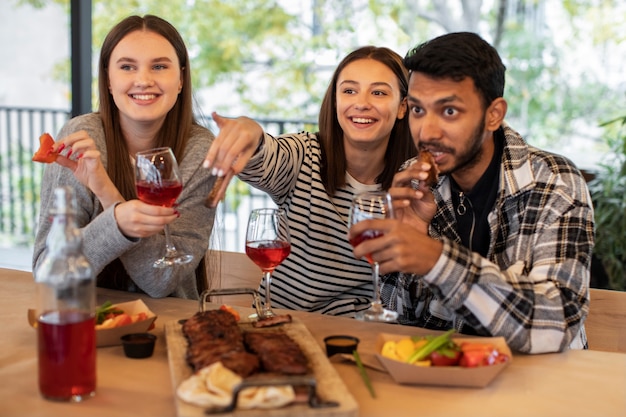 Photo gratuite amis mangeant et buvant lors d'une réunion