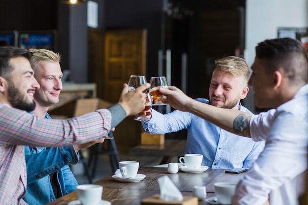 Amis masculins appréciant les boissons du soir dans le bar