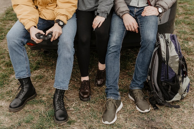 Photo gratuite amis méconnaissables assis ensemble à l'extérieur