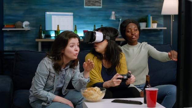 Des amis multiethniques expérimentant la réalité virtuelle perdant un jeu vidéo portant un casque vr lors d'une compétition de jeux. groupe de race mixte de personnes traînant ensemble s'amusant tard dans la nuit dans le salon