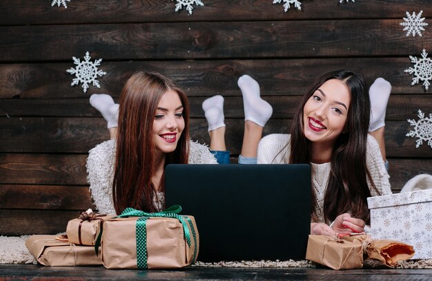 Amis avec un ordinateur portable et cadeaux de Noël