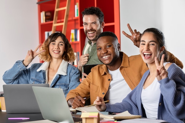 Amis pendant la session d'étude apprenant et montrant le signe de paix