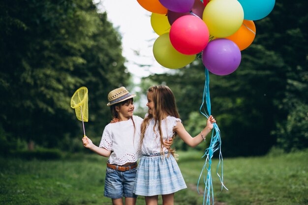 Photo gratuite amis de petites filles avec des ballons en forêt