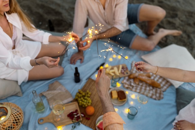 Amis à la plage avec des cierges magiques