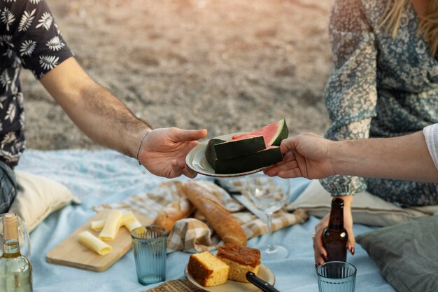 Amis à la plage avec pastèque et bière