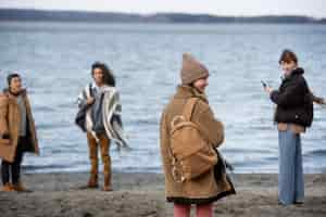 Photo gratuite amis de plan moyen au bord de la mer