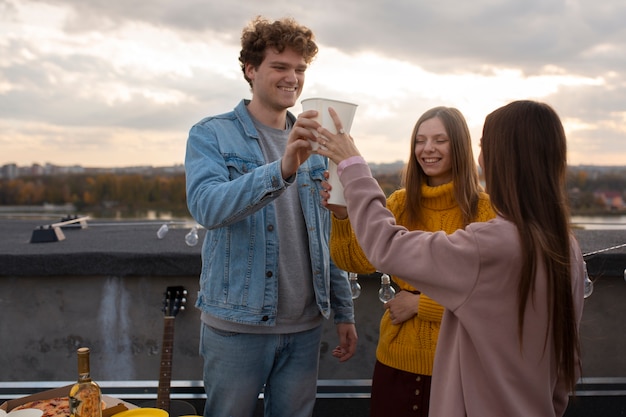 Amis de plan moyen faisant tinter les tasses