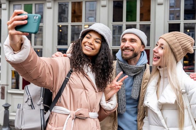 Amis de plan moyen prenant selfie