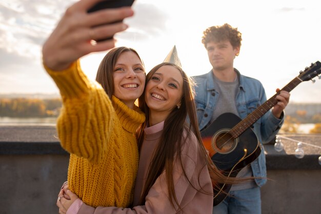 Amis de plan moyen prenant un selfie