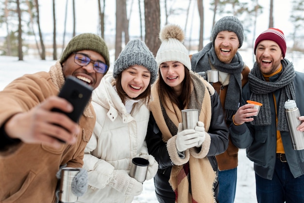 Amis de plan moyen prenant selfie