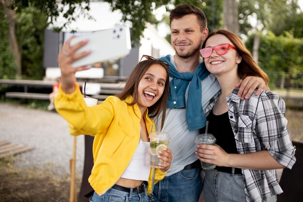 Amis de plan moyen prenant des selfies