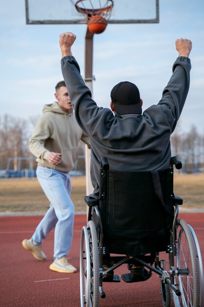 Amis plein coup jouant au basket à l'extérieur