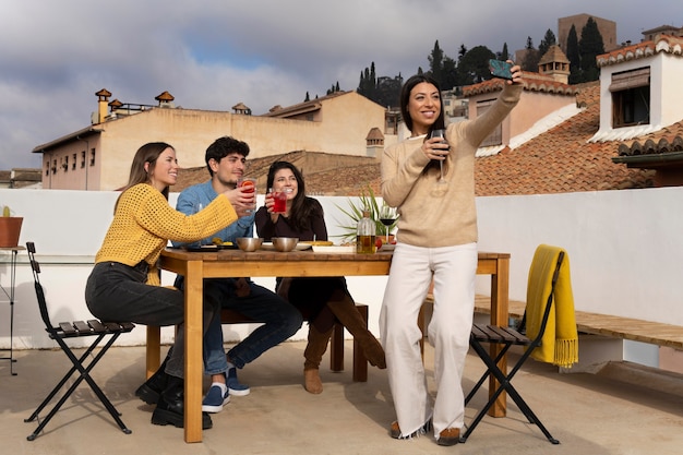 Photo gratuite amis plein coup prenant selfie à l'extérieur