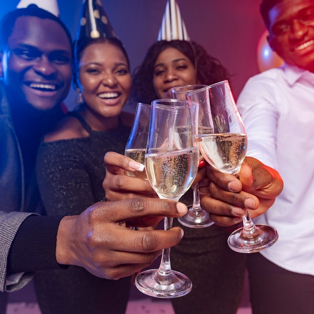 Photo gratuite amis portant des chapeaux de fête et grillage avec champagne