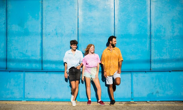 Amis posant avec mur bleu