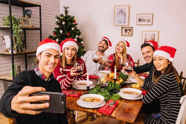 Amis prenant selfie au dîner de Noël