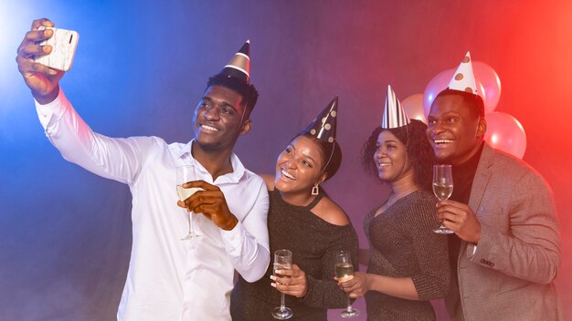 Amis prenant un selfie à la fête