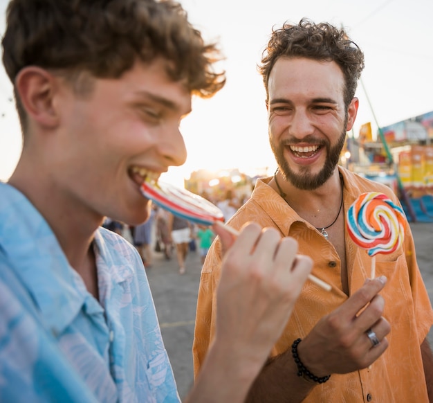 Amis profitant de la sucette à la fête foraine