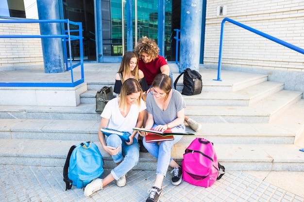 Amis qui étudient sur les marches du bâtiment de l&#39;université