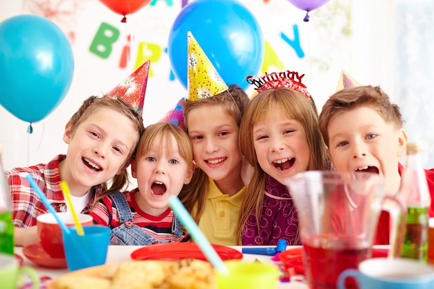 est assis près de la table. les enfants célébrant la fête d'anniversaire à  l'intérieur s'amusent ensemble 15364892 Photo de stock chez Vecteezy