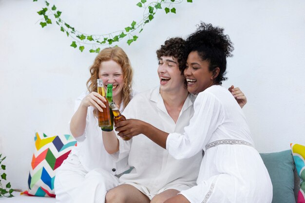 Amis s'amusant avec des boissons lors d'une soirée blanche