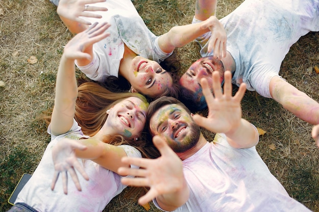 amis s'amusant dans un parc avec des peintures holi