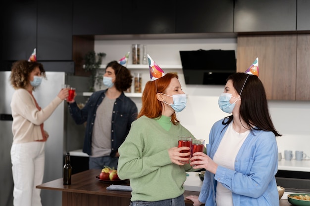 Amis s'amusant à la fête pendant covid