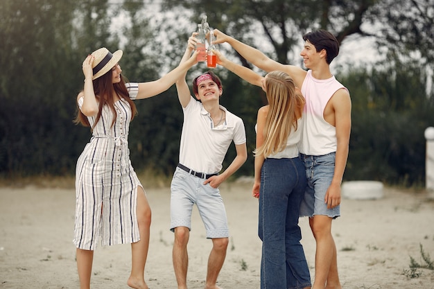 Les amis s'amusent sur une plage avec des boissons