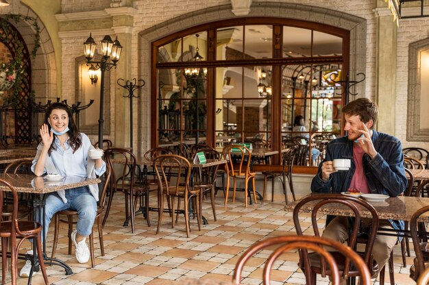 Des amis se saluent tout en respectant la distance sociale