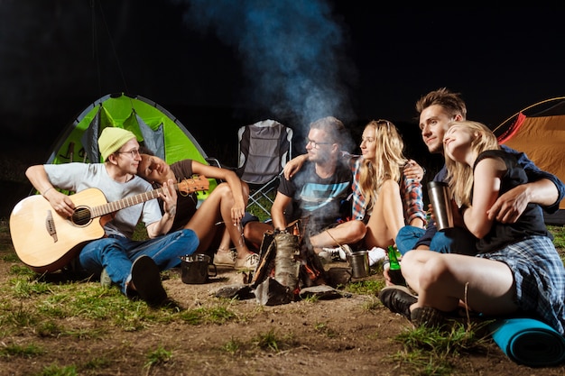 Amis, séance, près, feu de joie, sourire, embrasser, reposer, jouer guitare