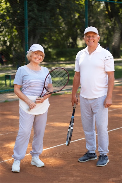 Amis seniors en plein coup tenant des raquettes