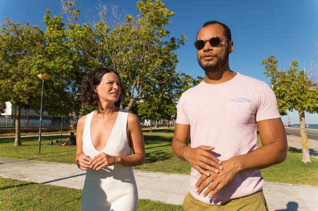 Amis sérieux marchant dans le parc