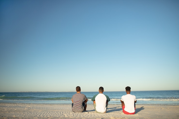 Photo gratuit amis de sexe masculin se détendre ensemble sur la plage