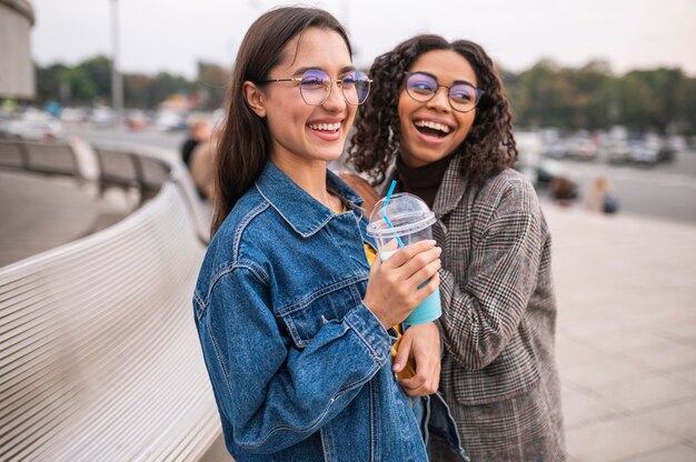 Amis Smiley s'amusant ensemble à l'extérieur avec des milkshakes