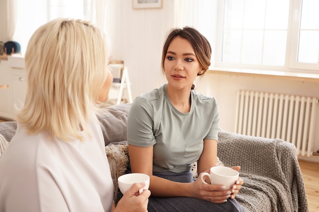 Des amis sont assis et discutent sur le canapé